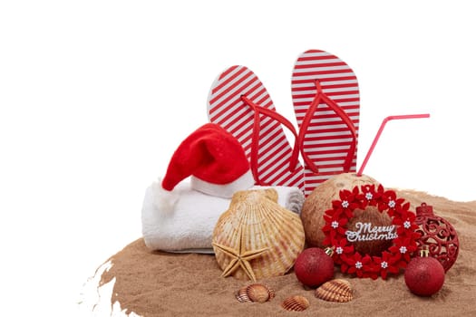Still life with beach accessories (flip flops, towel, seashells, sand, coconut) and christmas ornaments on white background. Christmas. Winter vacation in warm countries, beach holiday