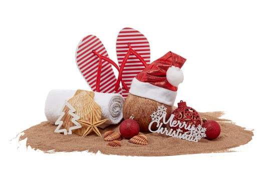 Still life with beach accessories (flip flops, towel, seashells, sand, coconut) and christmas ornaments on white background. Christmas. Winter vacation in warm countries, beach holiday