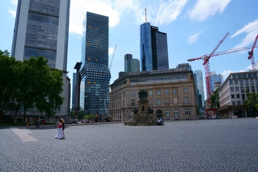 Frankfurt, Germany - July 06, 2019: The Rossmarkt with pedestrians and passers-by at the Johannes-Gutenberg-monument with fountain on July 06, 2019 in Frankfurt...