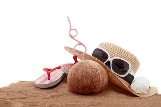 Beach accessories: flip flops, straw hat, sunglasses, sunscreen and coconut, lying on the sand on white background. Concept of sea vacation and travel. Summer background, Protection from uv