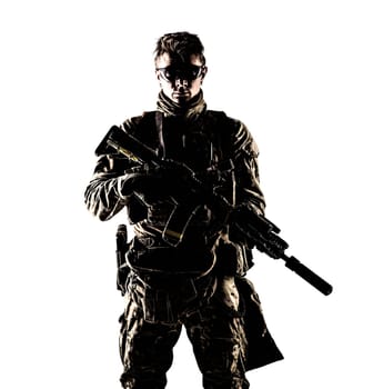 Military company mercenary, army special forces soldier, modern combatant in camouflage battle uniform, ballistic glasses, armed assault rifle with silencer low key studio portrait on white background