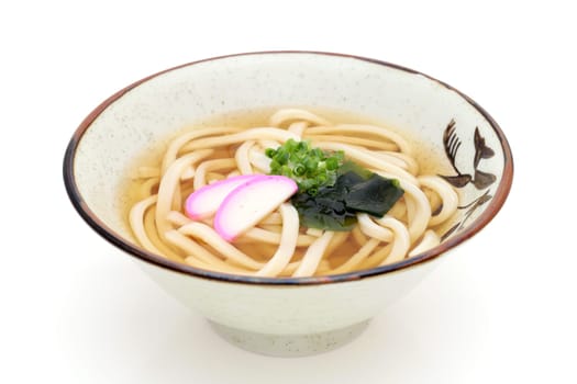 Japanese Kake udon noodles in a ceramic bowl on white background