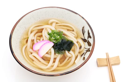 Japanese Kake udon noodles in a ceramic bowl on white background