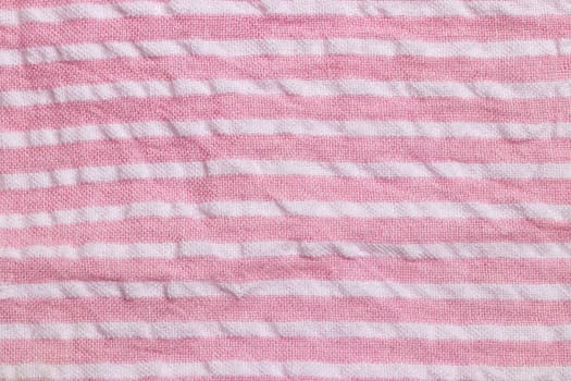 Textile background texture. Top view of details of a empty pink white striped summer dress. Beautiful backdrop for product display montage.