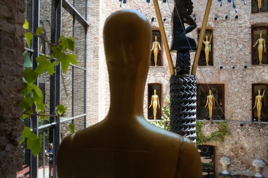 Salvador Dalì's Theatre Museum, Figueres, Spain: blurred close up of golden statue and partial view of the open courtyard, in background.