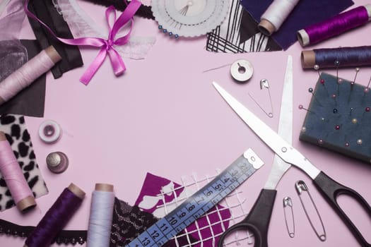 Sewing kit or sewing supplies are on pink background.