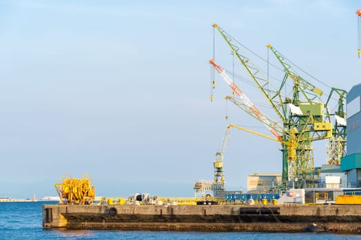 Hoisting cranes in the industrial zone of the Port in Kobe Hyogo Kansai Japan using for import export shipping and global business background