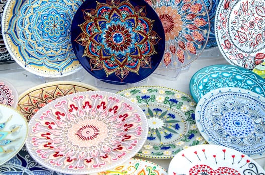 Ceramic plates, hand-painted with a dot pattern, are on the counter at the festive fair