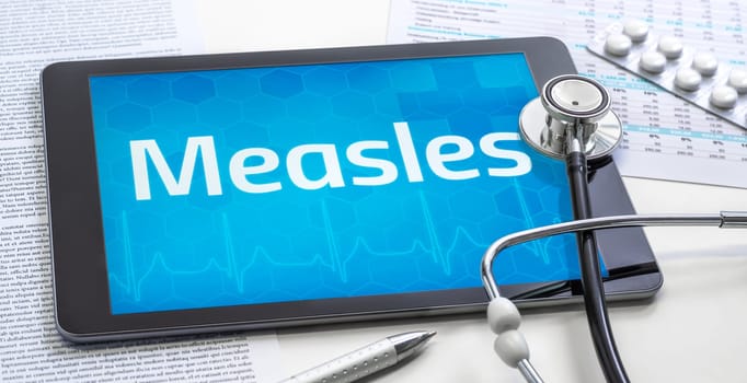 The word Measles on the display of a tablet