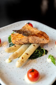 Grilled Salmon Fillet with grilled white asparagus serve with tomato and spinach