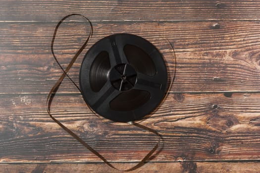 Vintage reel-to-reel audio recorder tape on wooden background