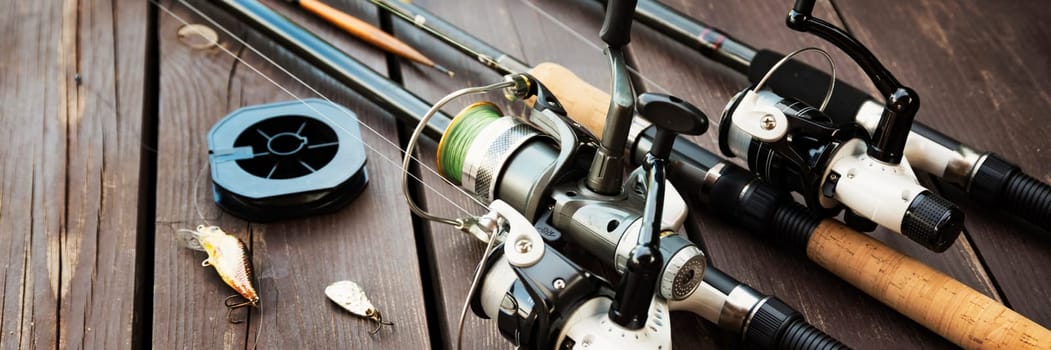 Fishing rods and accessories on wooden background with text space