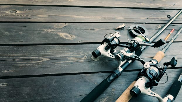 Fishing rods and accessories on wooden background with text space