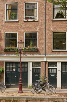 AMSTERDAM, NETHERLANDS - SEPTEMBER 21, 2017: Bicycle as popular way of transport in Amsterdam Netherlands parked and locked in front of traditional house in Holland.