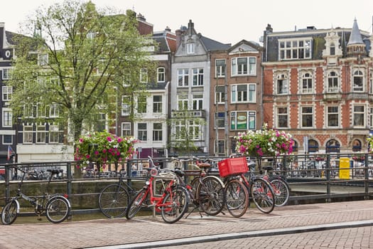 AMSTERDAM, NETHERLANDS - SEPTEMBER 21, 2017: Amsterdam canal with typical dutch houses and houseboats during morning in Holland, Netherlands.