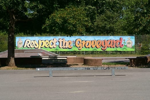 Walldorf, Germany - August 11, 2019: The skate tracks of a youth and sports park on the edge of a park landscape with graffiti on August 11, 2019 in Walldorf..