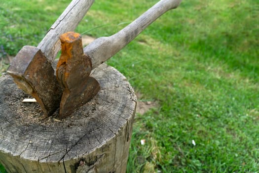 Two old rusted Axes on a wooden block