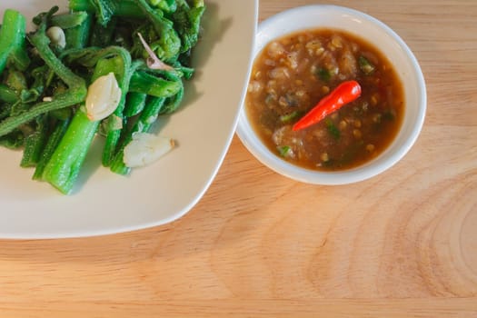 Thai cuisine nam prik or chili paste with vegetables on wooden
