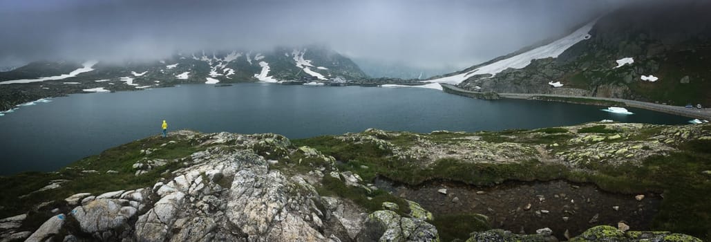 Young admiring the natural beauty of a glaciar lake in Swiss Alps - Panoramic image