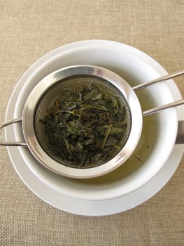 Green tea Sencha in a tea sieve
