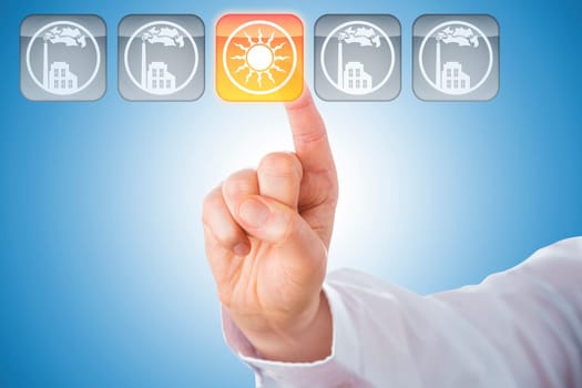 Close-up of a male index finger activating a yellow push button showing a solar energy icon. Four other keys with factory symbols do remain grey. Concept for energy turn. Blue background. Copy space.