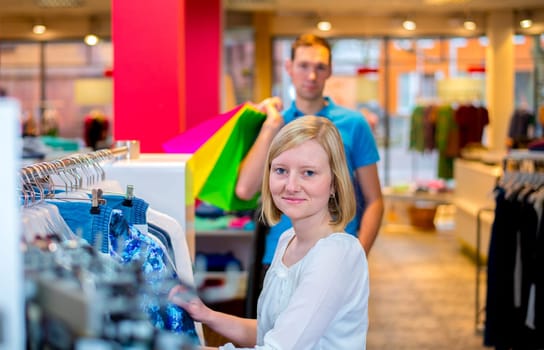 young couple in the clothes shop looking for a new dress