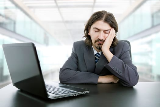 young businessman sleeping on the laptop at the office