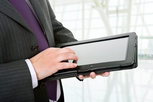 businessman using touch pad, close up shot on tablet pc, at the office