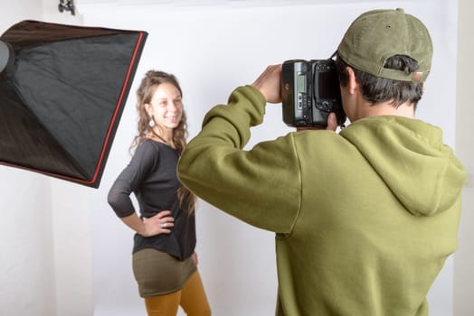a photographer photograph his model in his studio