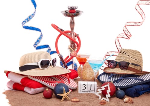 Beach accessories, seashells, sand, two glasses of cocktail, hookah (shisha) and christmas ornaments on white background. New Year. Winter vacation in warm countries, beach holiday