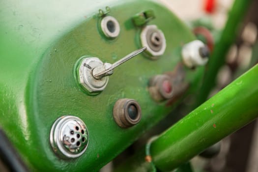 Grün überlackiertes Amaturenbrett mit Starter-Schalter eines alten Traktors deutscher Fabrikation.