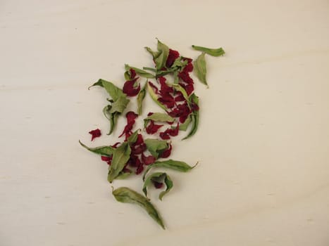 Dried pomegranate leaves and dried pomegranate flowers on a wooden board
