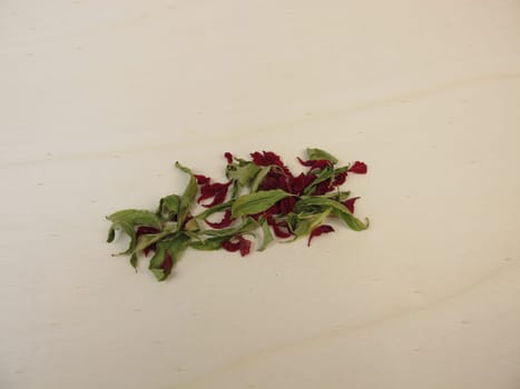 Dried pomegranate leaves and dried pomegranate flowers on a wooden board