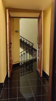 Open wooden door building architecture staps black ceramic floor room apartment hotel interior design . High quality photo