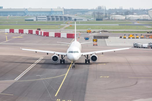 White Airplane waiting on taxiway ready to takeoff