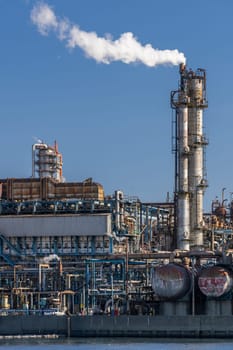 Oil petrochemical Factory plant with gas storage and structure of pipeline with smoke from smokestack in Kawasaki City near Tokyo Japan
