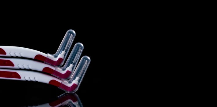 Three interdental brush with cover isolated on black background with copy space for text. Dental care concept. Equipment for get rid of food stuck in teeth