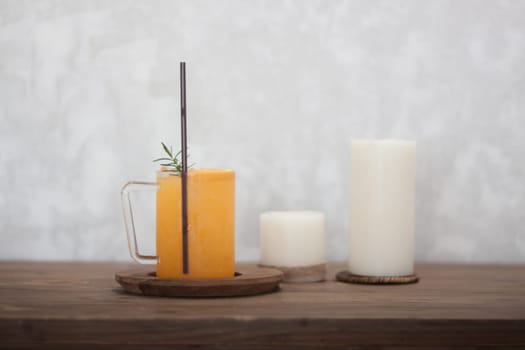Glass of fresh orange juice with slice on wooden table