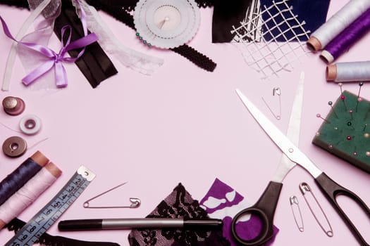 Sewing kit or sewing supplies are on pink background.