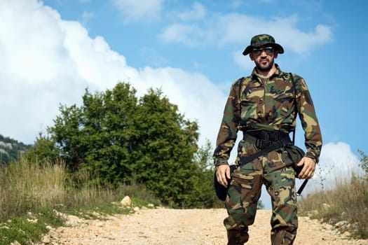 Man in military uniform is in nature outdoors, adventure concept.