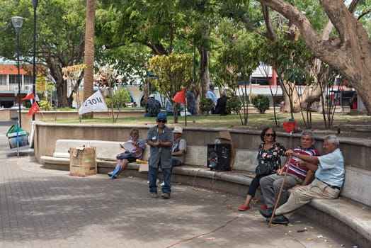 elderly panamanese sitting on a stone bench in the miguel de cervantes saavedra park david panama