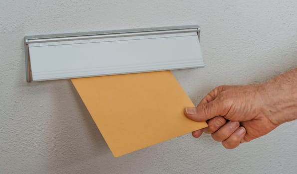 A brown letter with copy space in a mail slot
