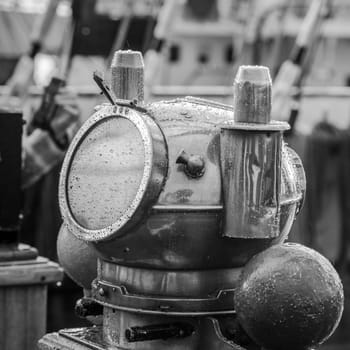 Reflection of a mast in an old ship compass, closeup. Black and white photo