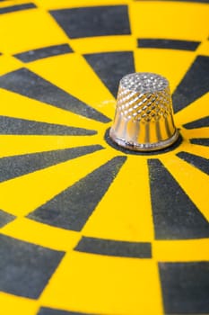 a thimble on an dartboard - symbol foto - closeup