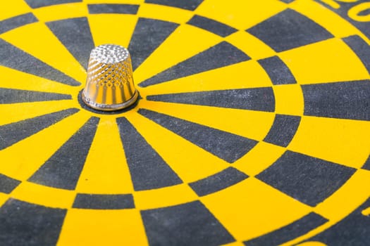 a thimble on an dartboard - symbol foto - closeup