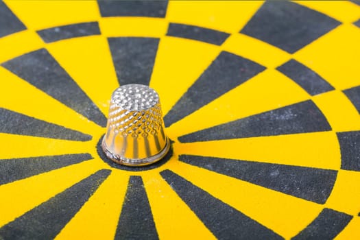 a thimble on an dartboard - symbol foto - closeup
