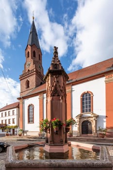 Protestant Church Edenkoben Germany Rhineland Palatinate with fountain and cloudy blue sky