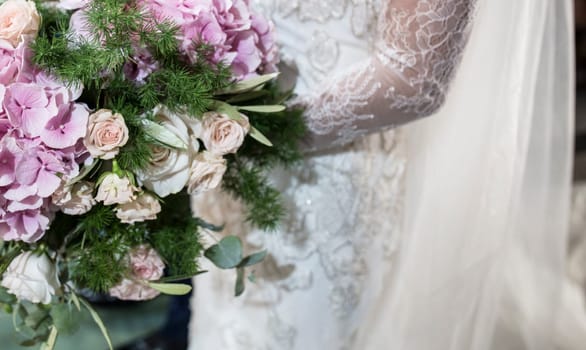 Bride holds big bouquet during ceremony. Couple standing in church for holy matrimony
