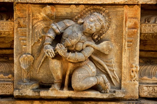 Close-up of stone sculpture of bean player on wall at Rayara Gopura in Melukote, Mandya district, Karnataka, India, Asia