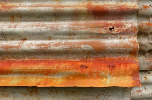 Rust on old corrugated metal sheets of a house wall